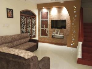 a living room with a couch and a tv at Kamala villa in Jaffna