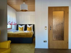 1 dormitorio con 1 cama con almohadas amarillas y puerta en Apartment Meertraum Steinhude, en Steinhude