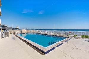 a swimming pool with the beach in the background at Oceania Plaza 808 in New Smyrna Beach