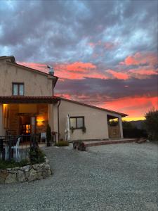 a house with a sunset in the background at Agriturismo Millennial in Quarrata
