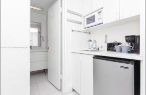cocina blanca con armarios blancos y lavavajillas en UNIT #1108 Castle Beach Club Condominium, en Miami Beach