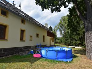 a blue tub sitting in the grass next to a house at Spacious Mountain Retreat in Lampertice
