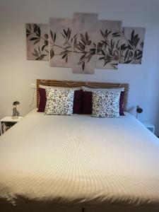 een slaapkamer met een bed met twee schilderijen aan de muur bij "LAGO VERDE" Como garage privato in Como