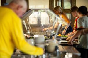 a group of people in a kitchen preparing food at YMCA Trout Lodge in Potosi