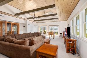 un soggiorno con un divano e un tavolo di Lakeside Getaway with Dock, Firepit, Grill a Newaygo