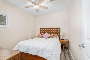 una camera da letto con un letto e un ventilatore a soffitto di Lakeside Getaway with Dock, Firepit, Grill a Newaygo