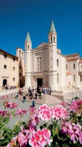 a large building with pink flowers in front of it at Villa Fiore in Cerreto di Spoleto