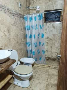 baño con 2 aseos y cortina de ducha en AlojamientolaFamilia, en Puerto Iguazú