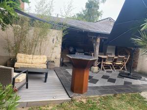Huisseau-sur-CossonにあるChambre aux portes de Chambordのテーブルと椅子とグリルのあるパティオ
