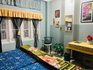 a bedroom with a bed and a table and a window at Namaskar Lodge and Homestay- 2026 Traveller Award Winner- only 18 mins from Kamakhya Temple in Guwahati