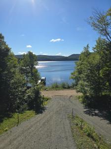 a dirt road next to a body of water at La Cabane du Couturier in Sainte-ThÃ¨cle