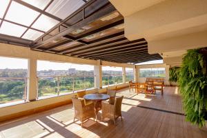 a balcony with a table and chairs and windows at Padom Business Hotel in Bragança Paulista