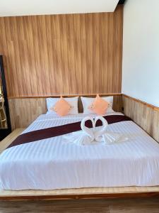 a bedroom with a bed with a ribbon on it at ตัง โฮเทล in Ban Rai Som