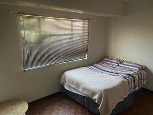 a small bedroom with a bed and a window at Home stay in Windsor west in Johannesburg