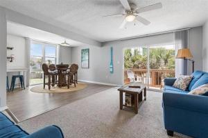 a living room with a blue couch and a table at Bombora Suites #202 | Flamingo Suite in Flagler Beach