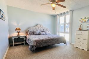 a bedroom with a bed and a ceiling fan at Bombora Suites #202 | Flamingo Suite in Flagler Beach