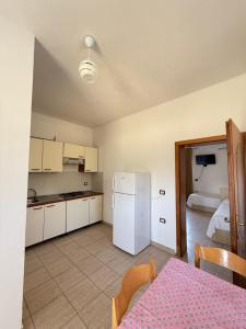 a kitchen with a table and a refrigerator in a room at Hotel Viluni in Baks-Rrjoll