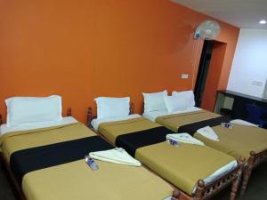 a group of three beds in a room at PRATHIBA RESIDENCY in Kollam +5 photos