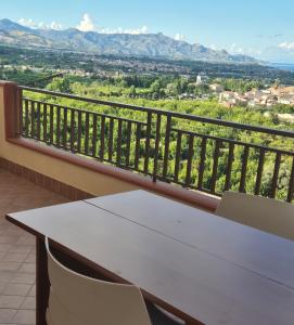 una mesa y sillas en un balcón con montañas en Casa Egle - Between Etna and the sea, en Giarre