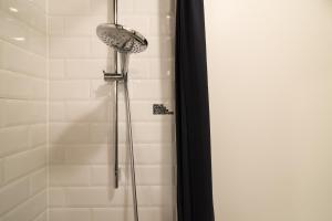a shower with a shower head in a bathroom at Jam Hotel Brussels in Brussels