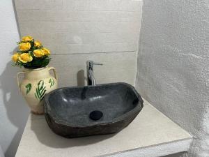 a black sink and a vase with yellow flowers at Casa Nunzia in Badolato +4 photos