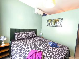 a bedroom with a bed with a black and white comforter at Studio 3 Praias in São Vicente +26 photos