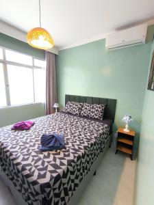a bedroom with a bed with a black and white comforter at Studio 3 Praias in São Vicente
