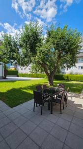 a table and chairs with a tree in a park at Appartements Luna in Schladming
