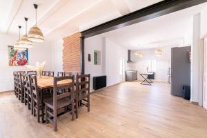 a dining room and living room with a table and chairs at Casa Rural Entre Almendros in El Toboso