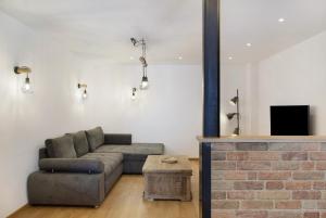 a living room with a couch and a brick fireplace at Beim Schweizer in Garmisch-Partenkirchen