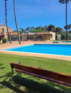 a wooden bench sitting in front of a swimming pool at Ofir Nature Stay in Fão