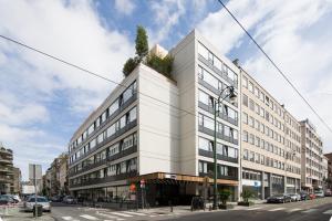 un edificio blanco con un árbol encima en JAM Brussels, en Bruselas