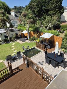 a deck with a table and chairs and a pool at Appletorre House Holiday Flats in Torquay +65 photos