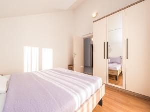 a bedroom with a large white bed and a sliding glass door at Apartment in Vrsi near the Sea in Vrsi +33 photos