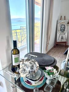 a glass table with a bottle of wine and dishes on it at ARTE MARE d'Irene in Spartos