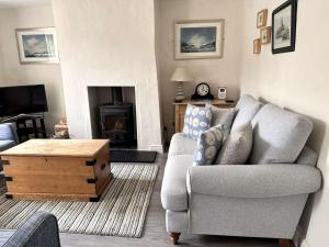 MAYS COTTAGE - Blakeney في بلايكيني: غرفة معيشة مع أريكة وطاولة قهوة +10 صور