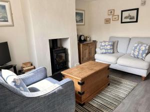 MAYS COTTAGE - Blakeney في بلايكيني: غرفة معيشة مع كنبتين ومدفأة