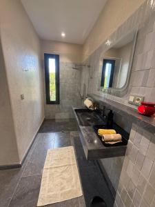 a bathroom with a sink and a mirror at Maison de campagne in Fès