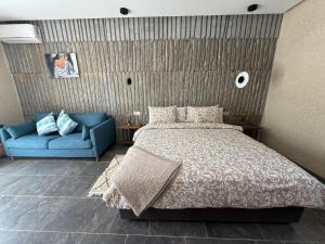 a bedroom with a bed and a blue couch at Maison de campagne in Fès