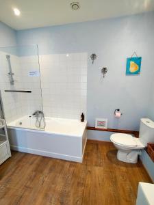 a bathroom with a white tub and a toilet at Les Grands Vents in Chervettes +33 photos