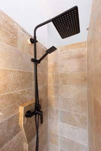 a shower with a shower head in a bathroom at Le 13 privé - Proche RER A - 20 min de Paris - Rue privée sécure in Rueil-Malmaison