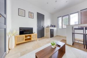 a living room with a table and a tv at Le 13 privé - Proche RER A - 20 min de Paris - Rue privée sécure in Rueil-Malmaison