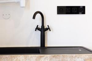 a kitchen sink with a black faucet at Le 13 privé - Proche RER A - 20 min de Paris - Rue privée sécure in Rueil-Malmaison +21 photos