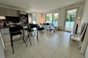 a kitchen and living room with a table and chairs at New apartment with large terrace! in Illkirch-Graffenstaden