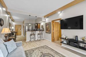 a living room with a couch and a flat screen tv at 301 Tuscan Breeze Getaway | Palm Coast in Palm Coast