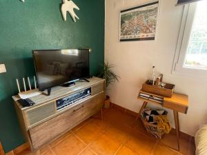 a living room with a flat screen tv on a entertainment center at DEl Rey Guest House in Tomar