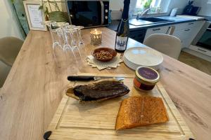 a wooden table with a sandwich on a cutting board at Le Catalpa in the heart of a farmhouse in Mittelhausbergen