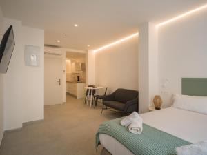 a hotel room with a bed and a chair at Shabolo Apartments Las Palmas in Las Palmas de Gran Canaria