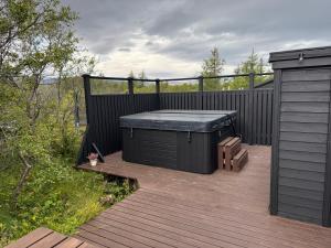 a hot tub sitting on a wooden deck at Salmon River Cabin in Þingeyjarsveit