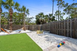 a backyard with a playground with a wooden fence at Stay Salty by Coastline Vacation Rentals in Cape San Blas